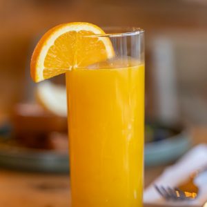 A vibrant glass of orange juice with a fresh orange slice for a healthy refreshment.